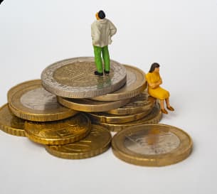 two plastic toys representing a men and a woman standing on real euros